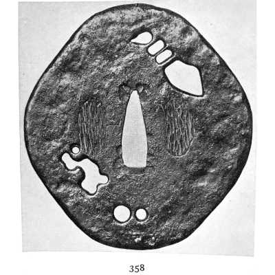 A metal tsuba (sword guard) with several cut-out (pierced) shapes, including an abstract pattern (design) and circular forms. The guard features textured surfaces (areas) suggesting either wear or deliberate patterning."
